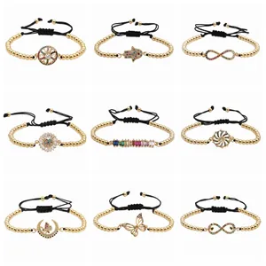 Set of nine beaded bracelets with gold beads, black cords, and colorful zircon charms