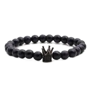 Bracciale di perline in pietra arenaria blu con ciondolo a corona nera su sfondo bianco