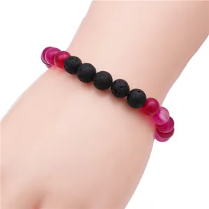 Detail view of crown bracelet featuring black volcanic stone and rose red agate beads