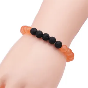 Detail of beaded crown bracelet with orange agate and black volcanic lava stone