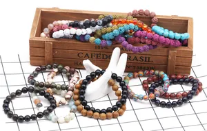 Detailed close-up of bohemian stone bead bracelets with crown charms and lava rock textures