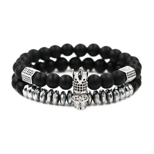 Detail of matte black stone and faceted hematite beaded bracelets with skull and crown