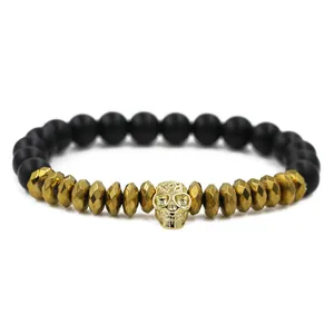 Men's matte black beaded bracelet with gold skull charm and crown accents