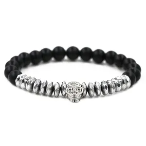 Close-up of black matte beaded bracelet with silver skull charm and crown detail