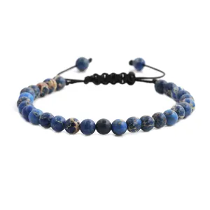 Gros plan d'un bracelet en perles d'oeil de tigre bleu avec cordon tressé noir réglable et texture