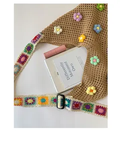 Dettaglio della borsa tote all'uncinetto con fiori 3D e tracolla larga colorata