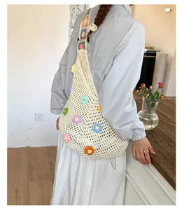 Dettaglio borsa tote all'uncinetto con fiori 3D colorati e tracolla geometrica vivace