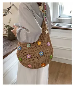 Dettaglio di fiori 3D in maglia su borsa tote all'uncinetto marrone con tracolla larga