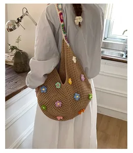 Dettaglio della tracolla a fiori all'uncinetto e della maglia strutturata della borsa tote