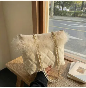 Detail of elegant beige quilted crossbody bag featuring soft faux fur trim and gold chain strap