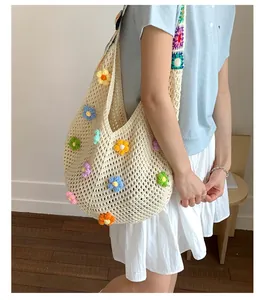 Dettaglio della borsa tote in maglia fatta a mano con fiori 3D colorati e tracolla