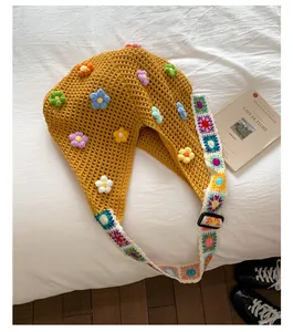 Dettaglio borsa tote in maglia giallo senape con fiori all'uncinetto colorati 3D
