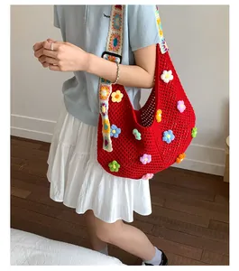 Dettaglio borsa tote rossa in maglia con fiori 3D e tracolla larga intrecciata