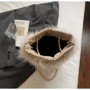 Detailed top view of off-white feather bucket bag with gold chain strap on soft grey background