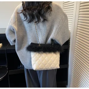 Detail of white quilted leather crossbody bag with black faux fur trim and gold chain