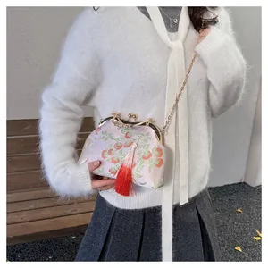 Detail of floral embroidery on a vintage evening bag with a swan clasp and long tassel