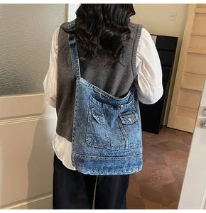 Vue arrière d'un grand sac fourre-tout vintage en denim lavé bleu porté à l'épaule