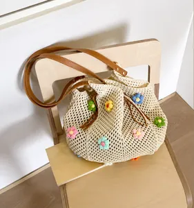 Detail of hollow knit tote bag featuring colorful 3D crochet flowers and leather handles