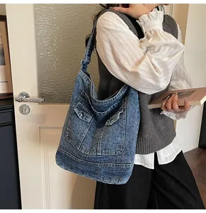 Détail du sac cabas en denim lavé vintage avec poches utilitaires et surpiqûres
