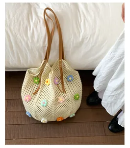 Close-up of hollow knit tote bag with colorful 3D crochet flowers and brown leather straps
