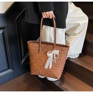 Detail of vintage brown woven tote bag with pearl lace charm on retro wooden stairs
