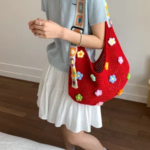 Dettaglio borsa shopper in maglia rossa con fiori all'uncinetto 3D e ampia tracolla decorata