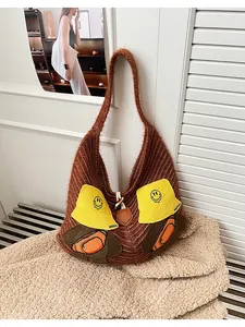 Close-up of brown knit tote bag featuring cute cartoon dog patches and soft texture