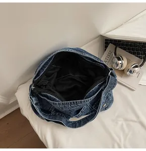 Détail du grand sac cabas en jean avec fermeture éclair et doublure intérieure noire