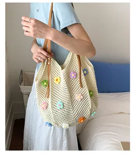 Detailed view of hollow knit tote bag with colorful crochet flowers and brown leather strap