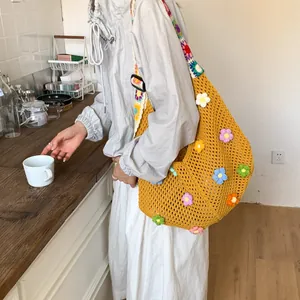 Dettaglio della borsa tote all'uncinetto con fiori 3D colorati e tracolla regolabile