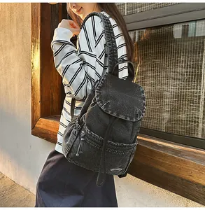 Detailed view of vintage washed denim backpack with drawstring closure and flap cover