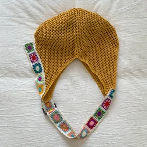Dettaglio di borsa tote in maglia senape con tracolla colorata all'uncinetto Granny Square
