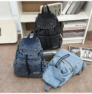 Close-up of three denim backpacks in black, dark blue, and light blue with drawstring caps