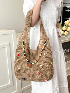 Handmade woven straw tote bag with colorful pom-poms and beads for beach holidays