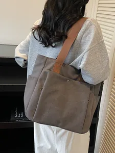 Minimalist dark grey canvas tote bag with brown straps for casual daily commuting