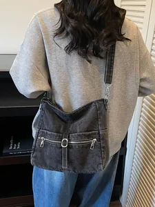 Vintage washed denim hobo bag in dark grey with shoulder strap and metal rings