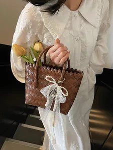 Retro straw tote bag in dark brown with lace bow and pearls for beach vacation