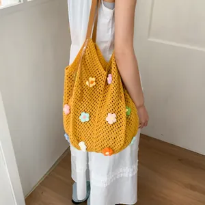 Detail of yellow hollow knit tote bag featuring colorful 3D handmade floral patches