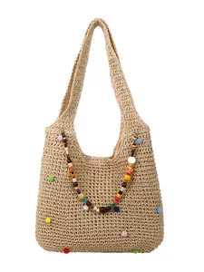 Woven straw beach tote bag with colorful pom-poms and beaded charm for summer vacation