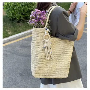 Détail d'un sac cabas en crochet avec franges bohèmes et breloque œil porte-bonheur
