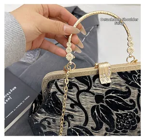 Detailed view of vintage kiss-lock closure and floral metal handle on floral jacquard bag