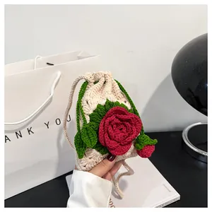 Primer plano detallado de la bolsa con cordón de ganchillo crema hecha a mano con rosa roja en 3D