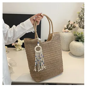 Détail d'un sac cabas en paille tissé à la main avec charm de pampille œil bleu