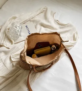 Detalle interior del bolso de paja con forro de lino y asa de bambú de estilo retro