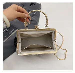 Detail view of the spacious inner compartment and elegant golden frame of the shell bag