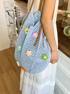Hollow-out knit tote bag with 3D crochet flowers and brown leather straps in light blue