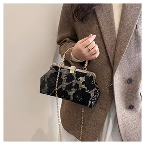 Detail of vintage floral shell bag with diamond-encrusted clasp and golden chain