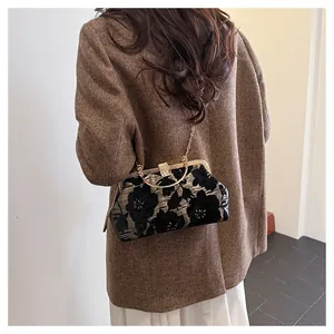 Detailed view of vintage black floral jacquard bag with gold ring handle and chain