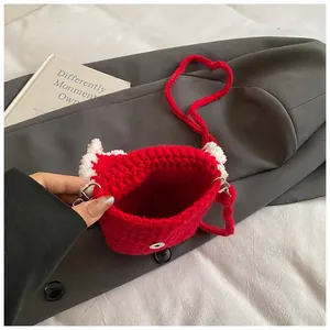 Détail d'un mini sac bandoulière rouge fait main au crochet avec oreilles en peluche blanche