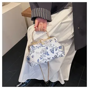 Detail of vintage Chinese style handbag with blue floral embroidery and gold metal clasp